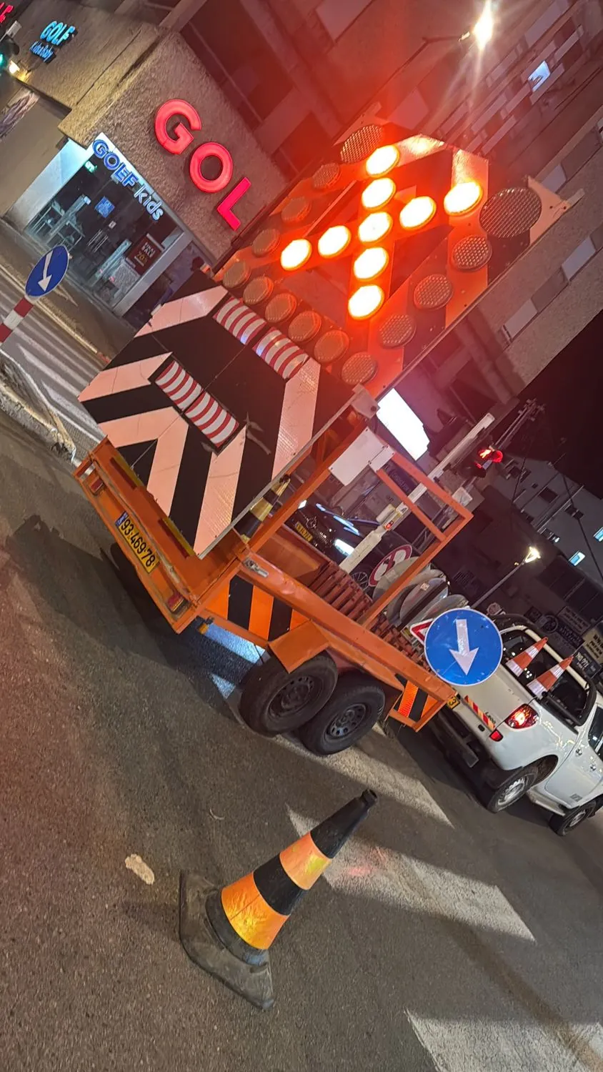 עגלת חץ מוארת בסגירת צומת בלילה לעבודות צבע