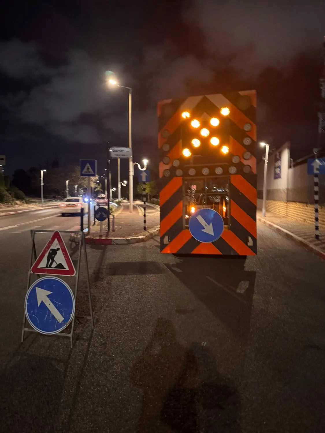 עגלת חץ מוארת בענבר בהכוונת תנועה בלילה