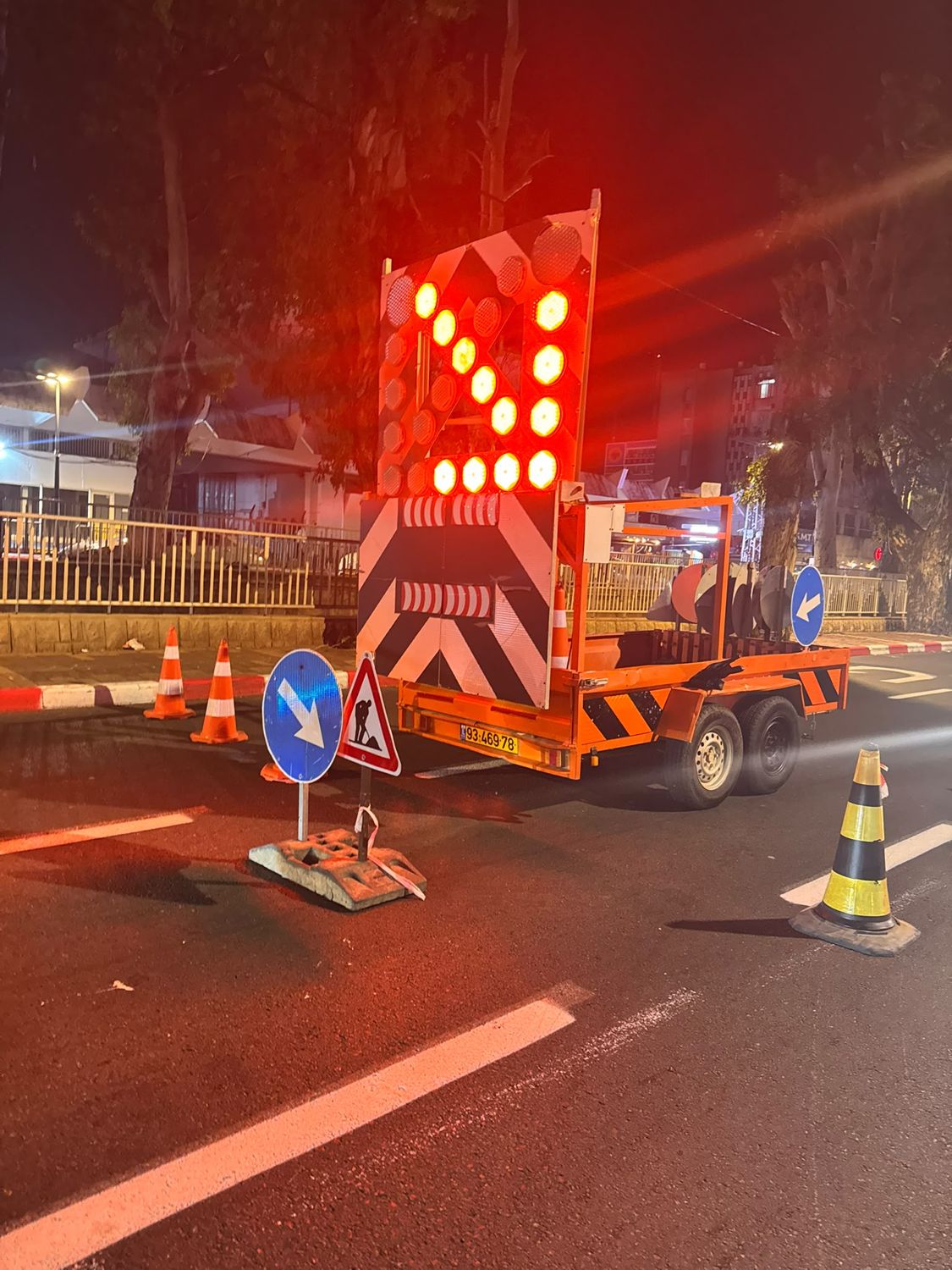 עגלת חץ נגררת מוארת בלילה בצד הכביש